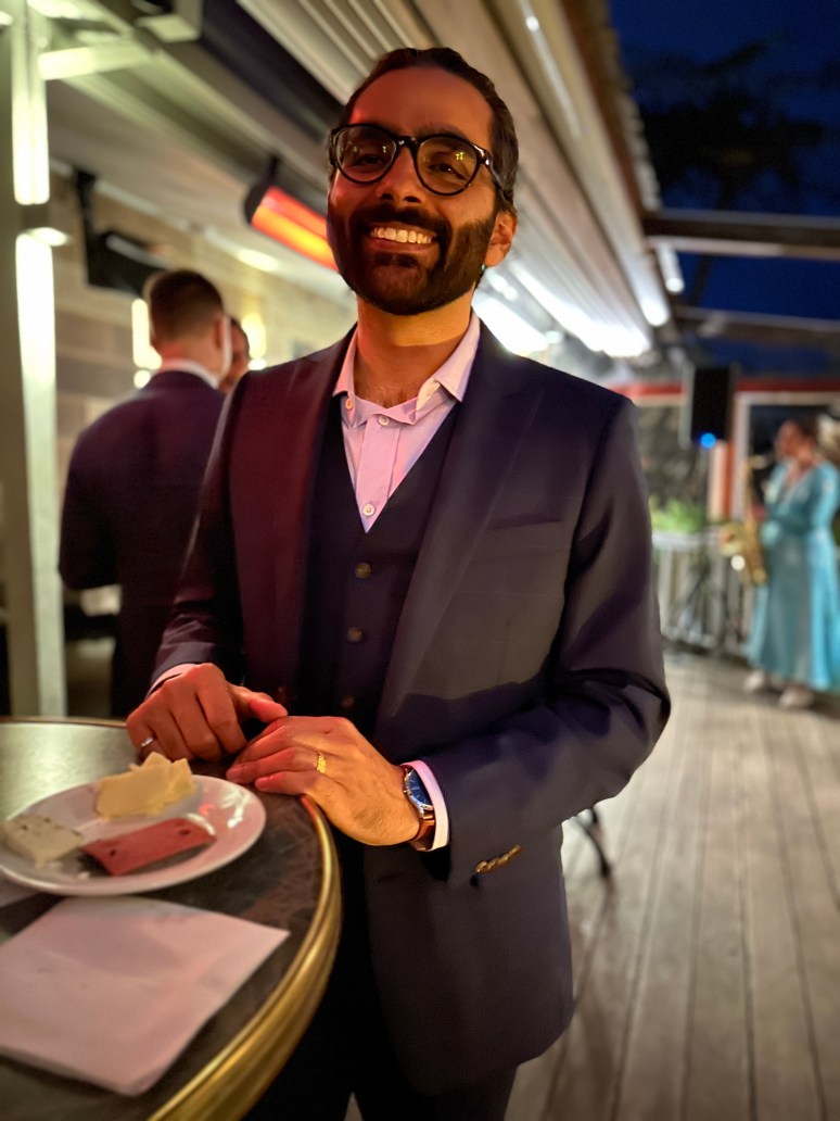 A picture of Gopal Krishnan smiling and enjoying a meal at an event 